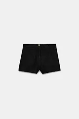 Short de tiro alto confeccionado en tweed negro, con cierre frontal y botón dorado decorativo.