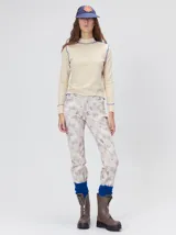 Polera de cuello alto confeccionada en tela rib color blanco, con mangas largas y hombreras. Presenta pespuntes en contraste en las terminaciones del cuello, hombros y puños.