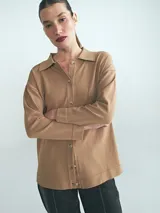 Cardigan de punto color tostado, con cuello camisero, cierre frontal de botones y mangas largas.