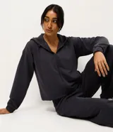 Campera deportiva Get Over de corte regular, confeccionada en tejido texturizado color gris oscuro. Presenta cierre frontal con zíper, capucha con cordones ajustables y mangas largas con puños elásticos.