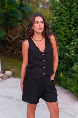 Conjunto de chaleco con botones y bermuda de crepé color rojo. El chaleco es sin mangas y con escote en V. La bermuda es de tiro alto y corte holgado.