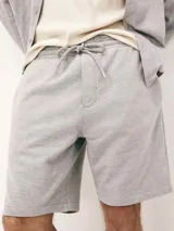 Bermuda deportiva gris con cintura elastizada y cordón de ajuste.