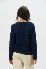 Sweater de punto de mohair color beige, con cuello redondo, mangas largas y detalles de terminación en color negro en el cuello, puños y ruedo.