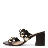Sandalia tipo mule de tacón ancho, color marrón oscuro, con dos tiras anchas adornadas con grandes apliques metálicos redondos de color dorado brillante.