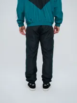Pantalón de jogging Umbro color azul marino, de corte recto, con cintura elástica y líneas blancas decorativas a los laterales. Presenta el logo de la marca bordado en blanco en la pierna izquierda.