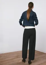 Pantalón de vestir negro de tiro medio y corte recto, con detalle de pinzas y bolsillos laterales.