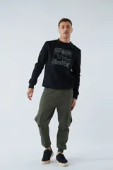 Buzo negro de felpa con cuello redondo, puños y mangas largas. Presenta un estampado con la frase "break the limits" y logo en goma.