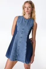 Vestido corto sin mangas, con silueta A y ruedo amplio, confeccionado en denim de dos tonos de azul. Presenta un panel central de denim celeste claro con costura central y paneles laterales de denim azul oscuro.