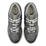 Championes urbanos New Balance modelo 1906R, color gris con detalles en amarillo. Presentan una estructura técnica con paneles de malla y refuerzos sintéticos, entresuela con tecnología de amortiguación y logo N lateral.