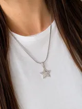 Collar de cadena tipo serpiente con dije de estrella pavé, elaborado en acero quirúrgico con acabado plateado.