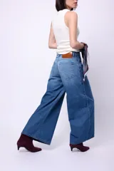 Jean de tiro alto con corte wide leg, confeccionado en denim azul clásico. Presenta etiqueta de cuero en la parte posterior y bolsillos traseros tradicionales.