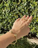 Anillo abierto de diseño minimalista y orgánico, realizado en metal macizo con extremos redondeados de diferentes tamaños.
