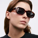 Lentes de sol unisex con armazón geométrico carey y lentes polarizadas negras.