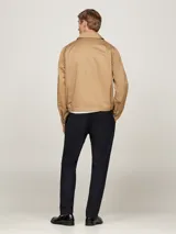 Campera Tommy Hilfiger modelo Ivy, color beige, de corte regular, confeccionada en algodón. Tiene cuello inglés, cierre de cremallera, dos bolsillos diagonales en la cintura, puños con botón y logo de la marca bordado en el pecho.