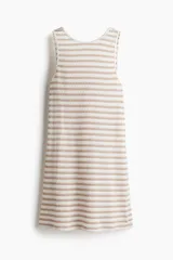 Vestido corto sin mangas de punto texturizado, con cuello redondo, espalda descubierta y diseño con leve vuelo. Presenta un patrón de rayas horizontales en tonos blanco y beige, con detalles de ribete festoneado en el cuello y las sisas.