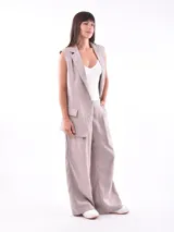 Chaleco largo color visón con solapas, sin mangas, con bolsillos frontales y cierre con dos botones.