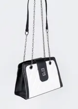 Cartera al hombro de cuero sintético, con diseño acolchado a rombos en blanco y negro. Tiene una repartición con cierre, correa de cadena y correa de cuero sintético.