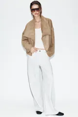 Chaqueta de efecto ante con cuello solapa envolvente, manga larga con hombro caído y bajo con elástico interior. Cuenta con bolsillos laterales ocultos en costura y forro interior.