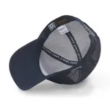 Gorra tipo trucker color azul marino con panel frontal de algodón y paneles laterales y traseros de malla. Presenta un parche rectangular en el frente con una ilustración de Goku en escala de grises.
