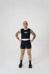 Musculosa corta negra de algodón elastizado con cuello y sisas ribeteadas en blanco. Estampado frontal con logo abstracto en blanco.