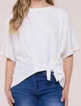 Remera blanca de manga corta, confeccionada en mezcla de modal, con diseño fluido y detalle de lazo ajustable en el lateral.