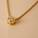Conjunto de tres collares de cadena fina en plata 925 con baño de oro, cada uno con un dije de punto de luz en forma de circonia engastada.