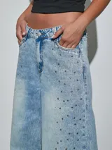 Jean de corte wide leg en color celeste, con diseño de lavado claro y detalle de tachas plateadas distribuidas por el frente.