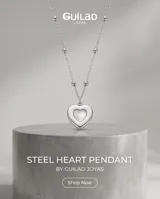 Collar de acero con cadena de eslabones y pequeñas cuentas esféricas, con dije colgante en forma de corazón con incrustación de nácar.