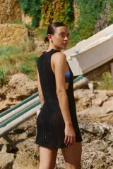 Vestido corto tejido sin mangas, con escote redondo y diseño de punto calado.