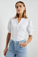 Remera blanca de algodón con mangas cortas abullonadas y cuello henley con tapeta de botones.