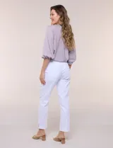 Pantalón ankle de tiro alto color blanco, confeccionado en tejido elástico con pretina ancha tipo pull-on, corte entallado y detalle de encaje calado en las aberturas laterales del ruedo.