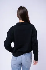 Sweater de punto con diseño de trenzas y rombos, color marrón, de cuello redondo y corte holgado.