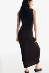 Vestido maxi sin mangas en punto con textura, color marrón oscuro. Modelo de corte ajustado con escote redondo y pliegues en un hombro y en un lado de la cintura para crear un leve efecto drapeado.