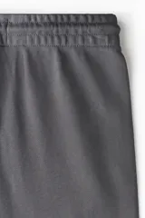 Pantalón deportivo gris oscuro de felpa de mezcla de algodón, con elástico y cordón ajustable en la cintura, bolsillos laterales y puños acanalados.