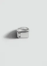 Anillo de zinc color plateado con diseño geométrico y aplicación de cristal tallado en corte baguette.