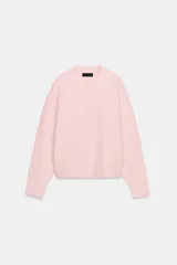 Jersey de punto de textura suave, color rosado, con cuello redondo y manga larga. Presenta un diseño de corte holgado con acabados en rib en cuello, puños y ruedo.