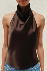 Top de cuello halter satinado en color naranja tostado, con espalda descubierta y cierre trasero de botones.