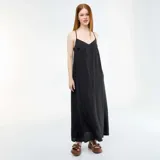 Vestido largo fluido color negro, con tirantes finos, escote en V y aberturas laterales en el bajo.