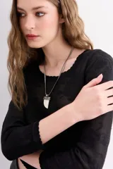 Collar con cadena plateada tipo víbora y dije colgante con forma de cuerno color hueso con detalles metálicos plateados.