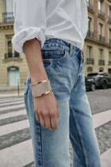 Pulsera ancha tipo brazalete rígido, con base metálica dorada y una sección central de malla de cadena plateada.