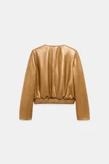 Campera bomber de cuero 100% color tostado de la ZARA WOMAN COLLECTION, con cuello redondo, manga larga, bolsillos delanteros ribeteados y cierre frontal con botones metálicos en relieve. Presenta elástico fruncido en el dobladillo inferior.