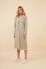 Tapado largo de corte recto confeccionado en lana fina sin teñir. Presenta cuello solapa, cierre frontal con botones, bolsillos laterales con tapa y detalles aplicados en la parte delantera. Incluye forro interior y tajo en la espalda.