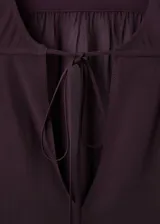 Blusa de viscosa color bordó, con escote en V y cierre de lazo, de manga larga con puños abotonados y diseño recto.