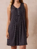 Camisón corto negro con estampado de lunares blancos, escote en V con botones y detalle plisado en el pecho.