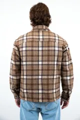 Camisa leñadora marrón a cuadros con forro de corderito sintético, cierre con botones y dos bolsillos frontales con tapa.