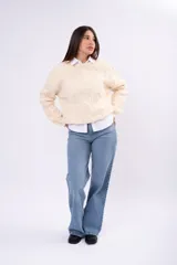 Sweater de punto con diseño de trenzas, cuello redondo y calce holgado.