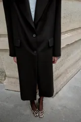 Zapato destalonado de piel con pelo, con estampado animal print. Presenta tacón alto ancho, tira trasera ajustable con hebilla metálica y acabado en punta cuadrada.