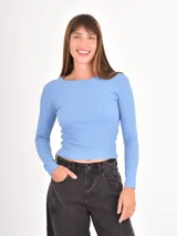Remera de manga larga ajustada al cuerpo, confeccionada en tejido acanalado de color celeste, con cuello redondo.