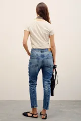 Pantalón de jean de corte recto y tiro medio con efecto acid wash y roturas sutiles en los bolsillos traseros.