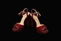 Sandalia de fiesta color bordó con plataforma y taco alto cuadrado. Presenta una tira frontal decorada con pedrería brillante y una tira ajustable con hebilla metálica en el tobillo.